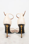 Pair of high-heeled shoes with gold accents on a marble surface