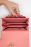 Pink interior of handbag held open by hands