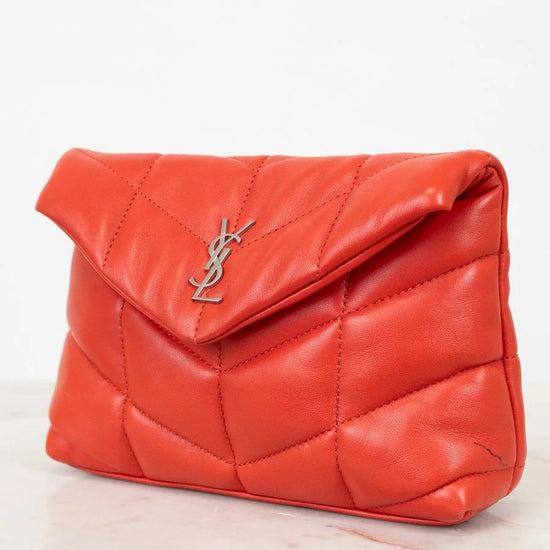 Red quilted handbag with a brand logo on a light background