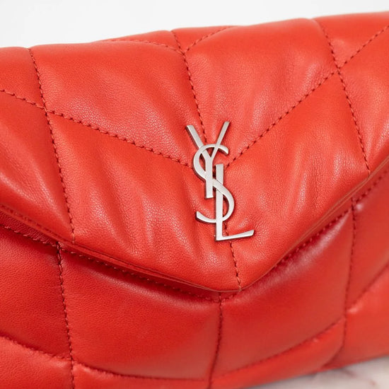 Red quilted handbag with a brand logo on a light background