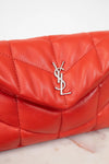 Red quilted handbag with a brand logo on a light background