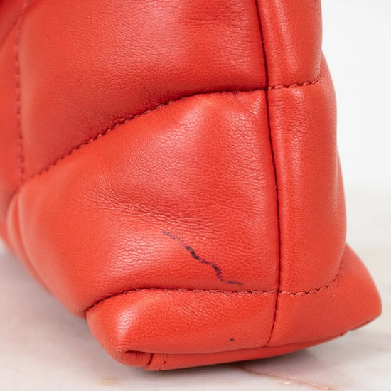 Close-up of a red leather glove with a visible scratch on a white background