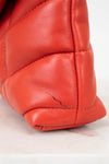 Close-up of a red leather glove with a visible scratch on a white background