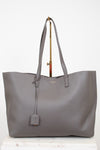 Gray tote bag with a "Saint Laurent" brand tag on a white background