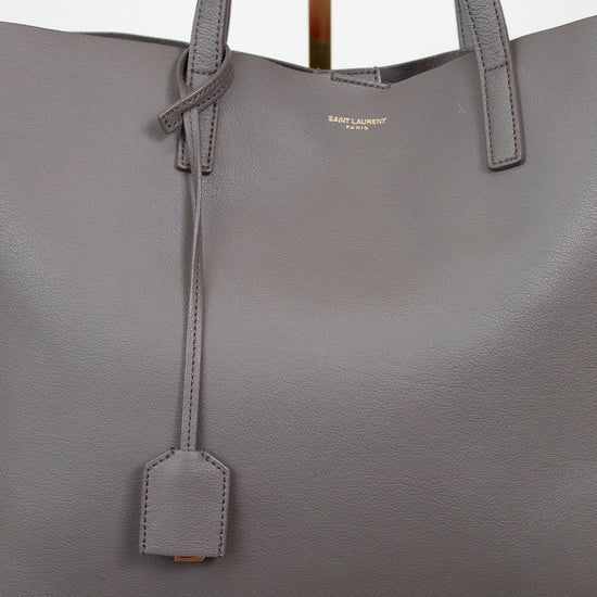 Gray handbag with a visible "Saint Laurent" brand logo on a light background