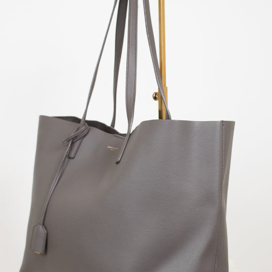 Gray tote bag with gold accents on a white background