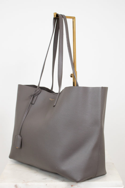 Gray tote bag with gold accents on a white background