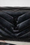 Black quilted handbag with a brand logo on a light background