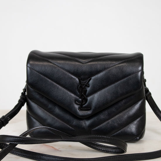 Black quilted handbag on a white background