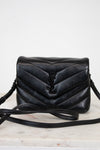 Black quilted handbag on a white background