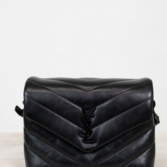 Black quilted handbag on a light gray background
