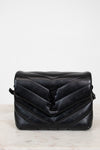 Black quilted handbag on a light gray background