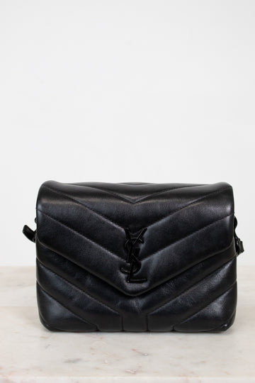 Black quilted handbag on a light gray background