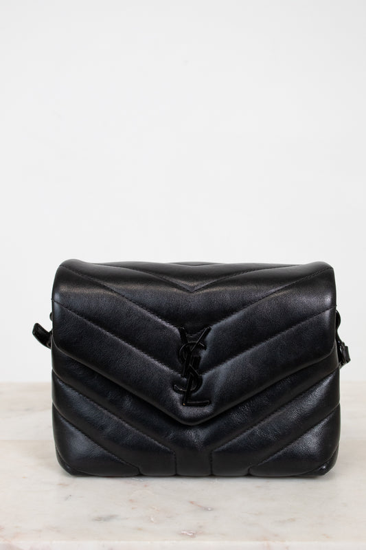 Black quilted handbag on a light gray background