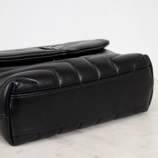 Black quilted handbag on a marble surface