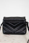 Black quilted handbag on a light marble surface