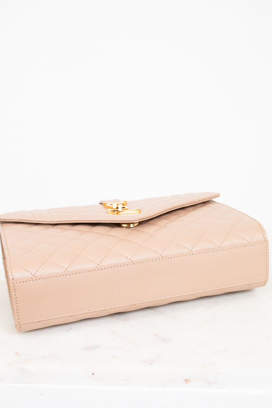 Beige handbag with gold clasp on a white background