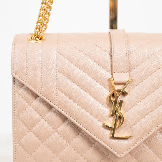 Quilted handbag with gold chain and logo on a light background