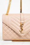 Quilted handbag with gold chain and logo on a light background