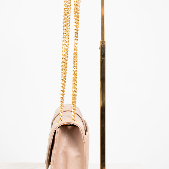 Beige handbag with gold chain and handle on a white background