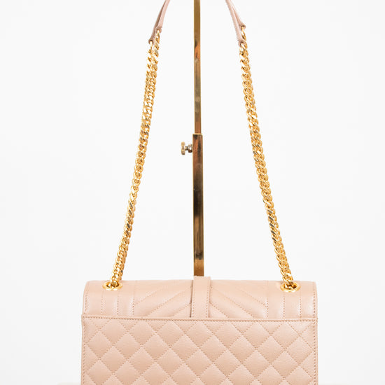 Beige quilted handbag with gold chain strap on a white background