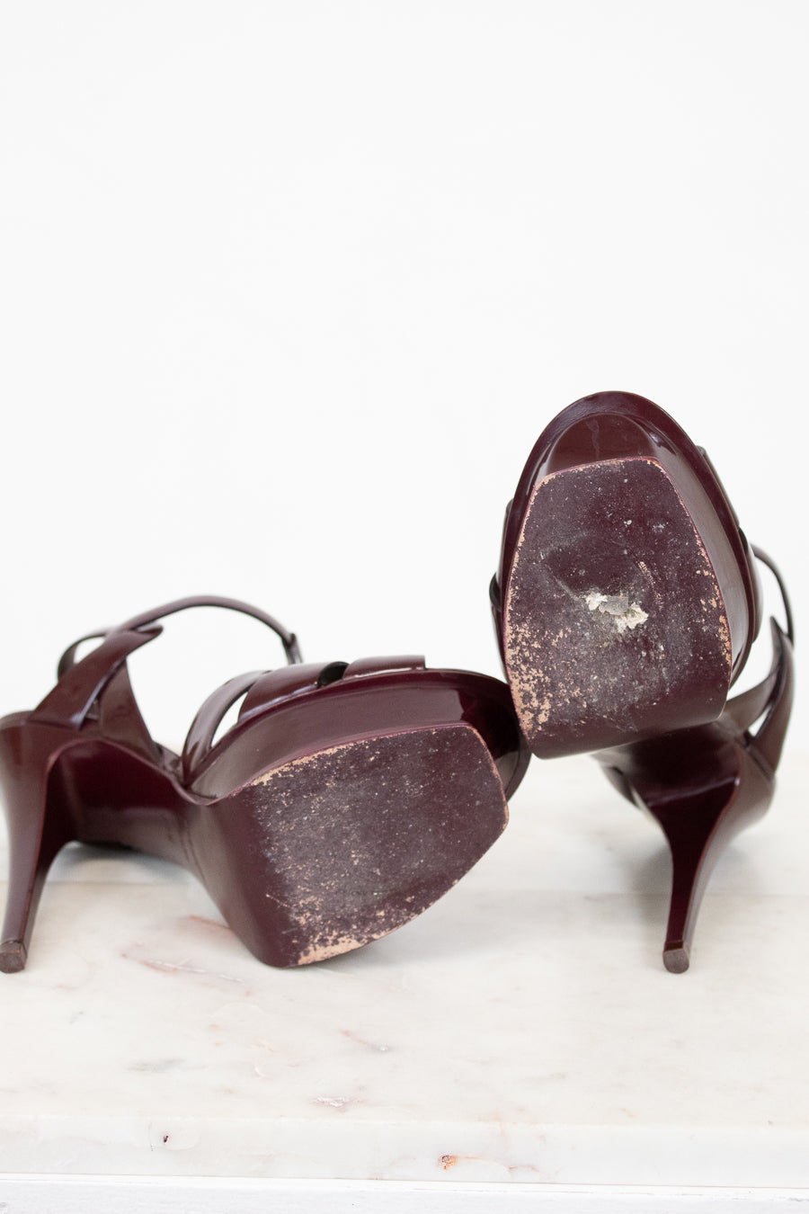 Pair of heels with scuffed soles on a white background