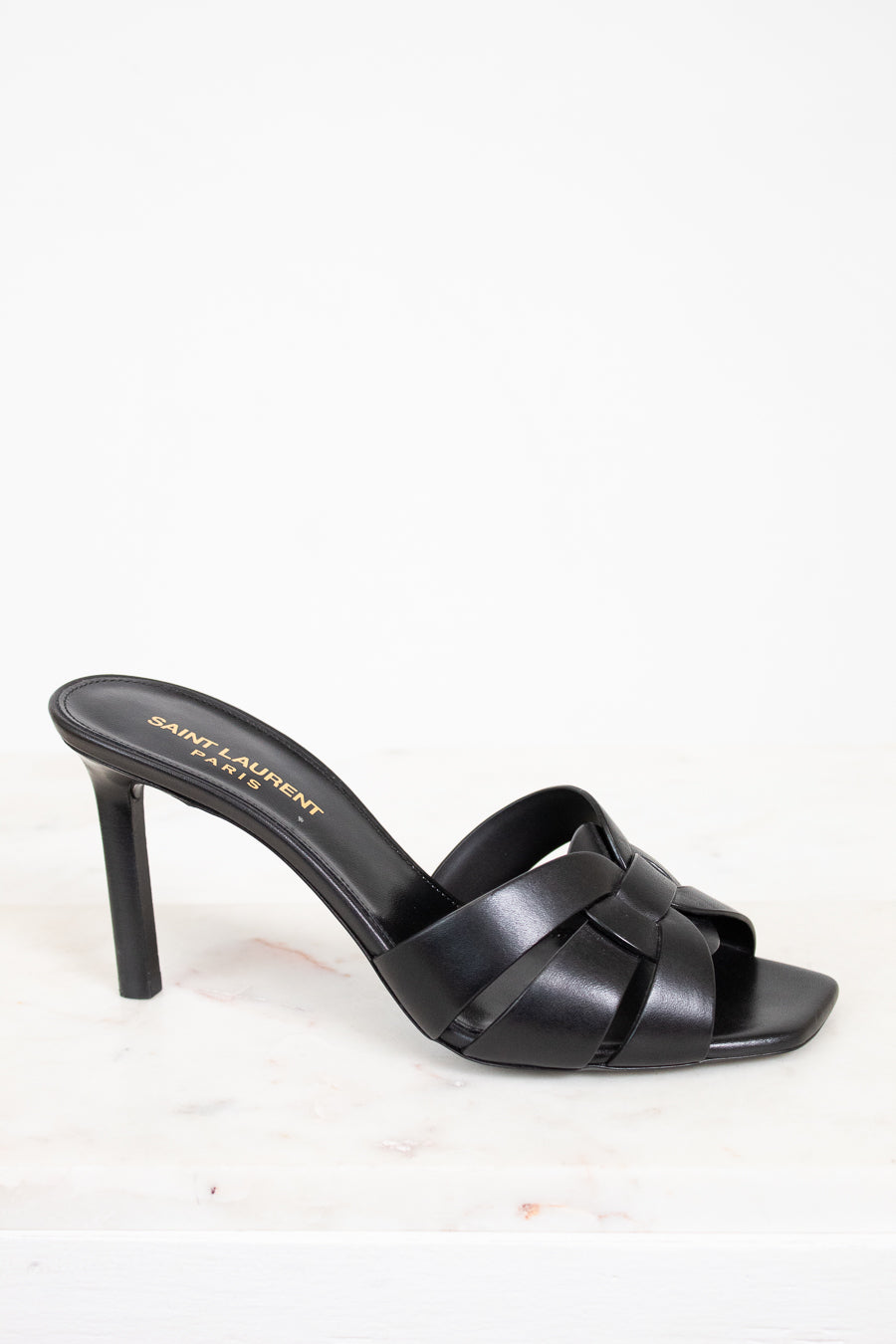Black sandal with criss-cross design on a white background