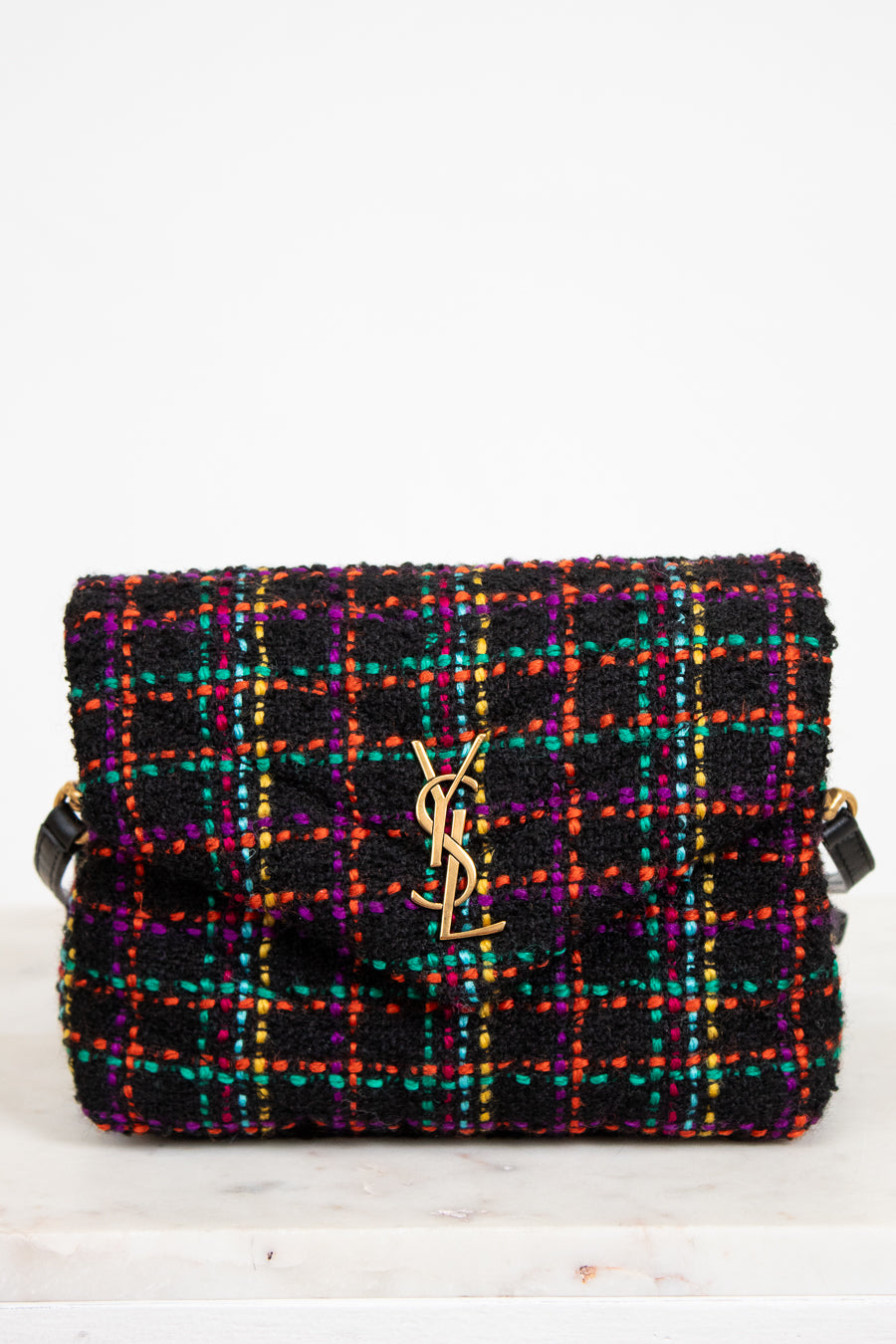 Multicolored tweed handbag with a brand logo on a white background