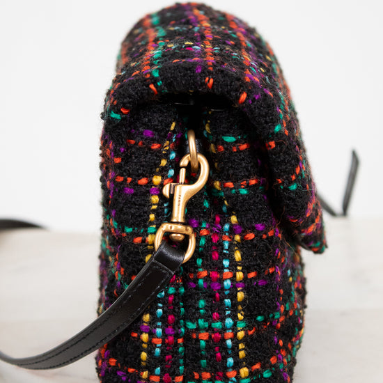 Multicolored textured handbag with a gold clasp on a white background