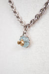Necklace with a blue stone pendant and gold bee charm on a white background