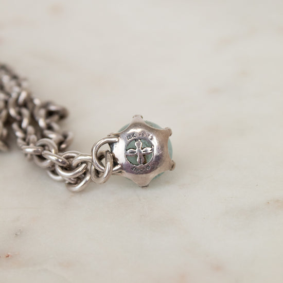 Silver charm bracelet on a marble surface