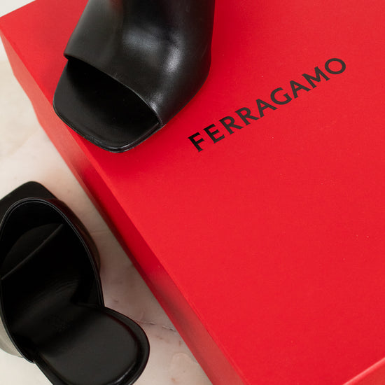 Black open-toe high heel shoe on a red Ferragamo box