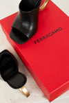 Black open-toe high heel shoe on a red Ferragamo box