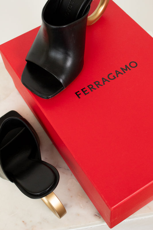 Black open-toe high heel shoe on a red Ferragamo box