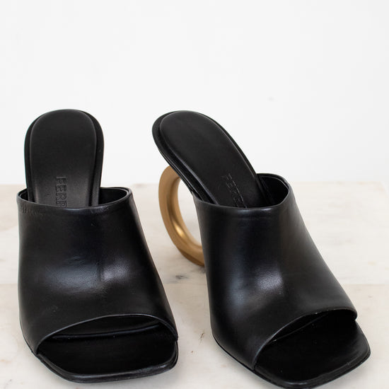 Pair of black open-toe high-heeled shoes on a light background