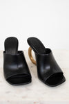 Pair of black open-toe high-heeled shoes on a light background