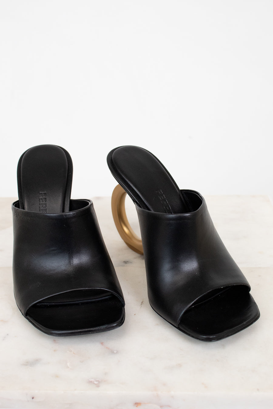 Pair of black open-toe high-heeled shoes on a light background