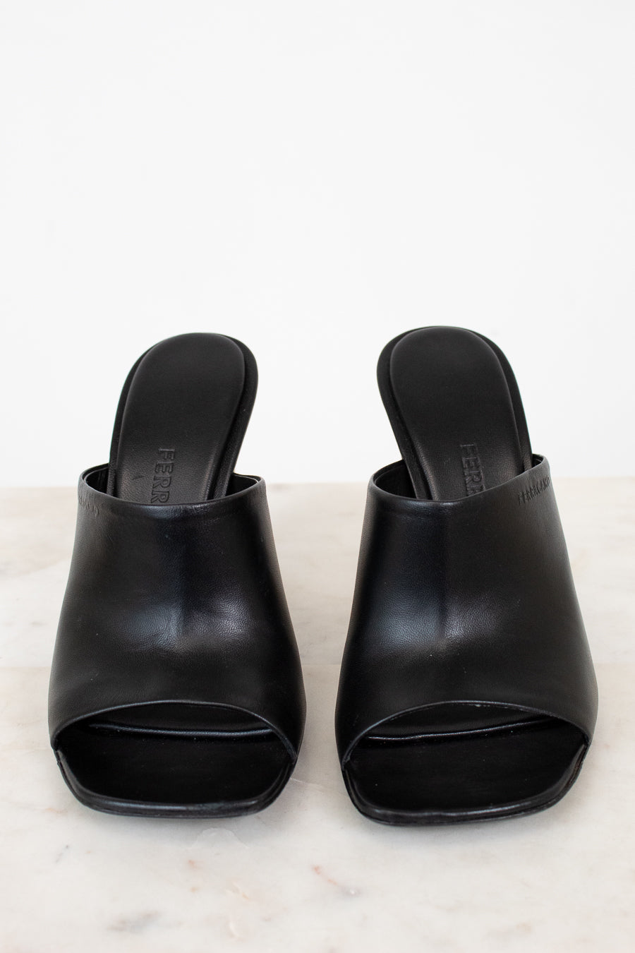 Pair of black open-toe shoes on a light gray background