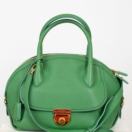 Green handbag with gold accents on a white background