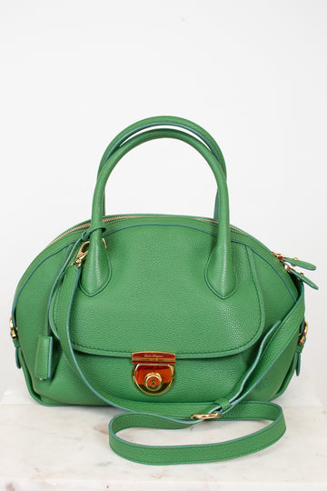 Green handbag with gold accents on a white background