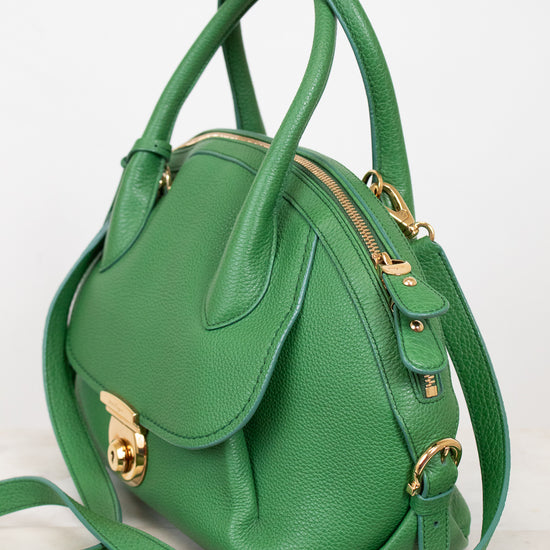 Green handbag with gold accents on a white background
