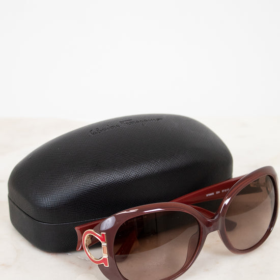 Sunglasses with a black case on a light background