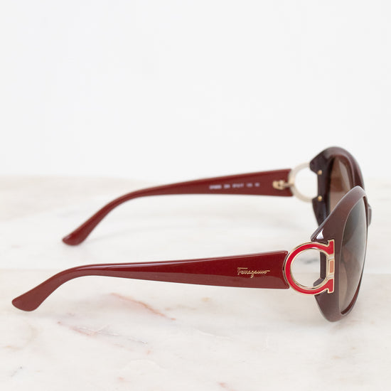 Red sunglasses with a brand logo on a white background
