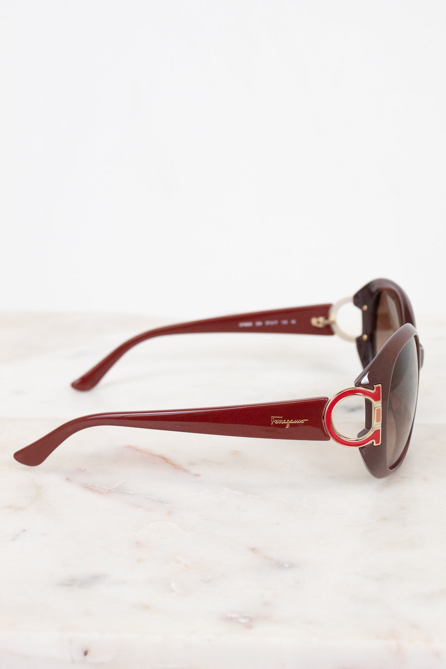 Red sunglasses with a brand logo on a white background