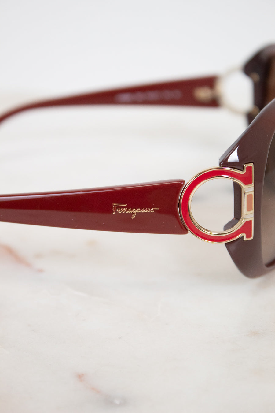 Sunglasses with a prominent brand logo on a light background