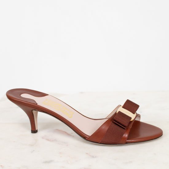 Brown high-heeled sandal with a bow on a white background