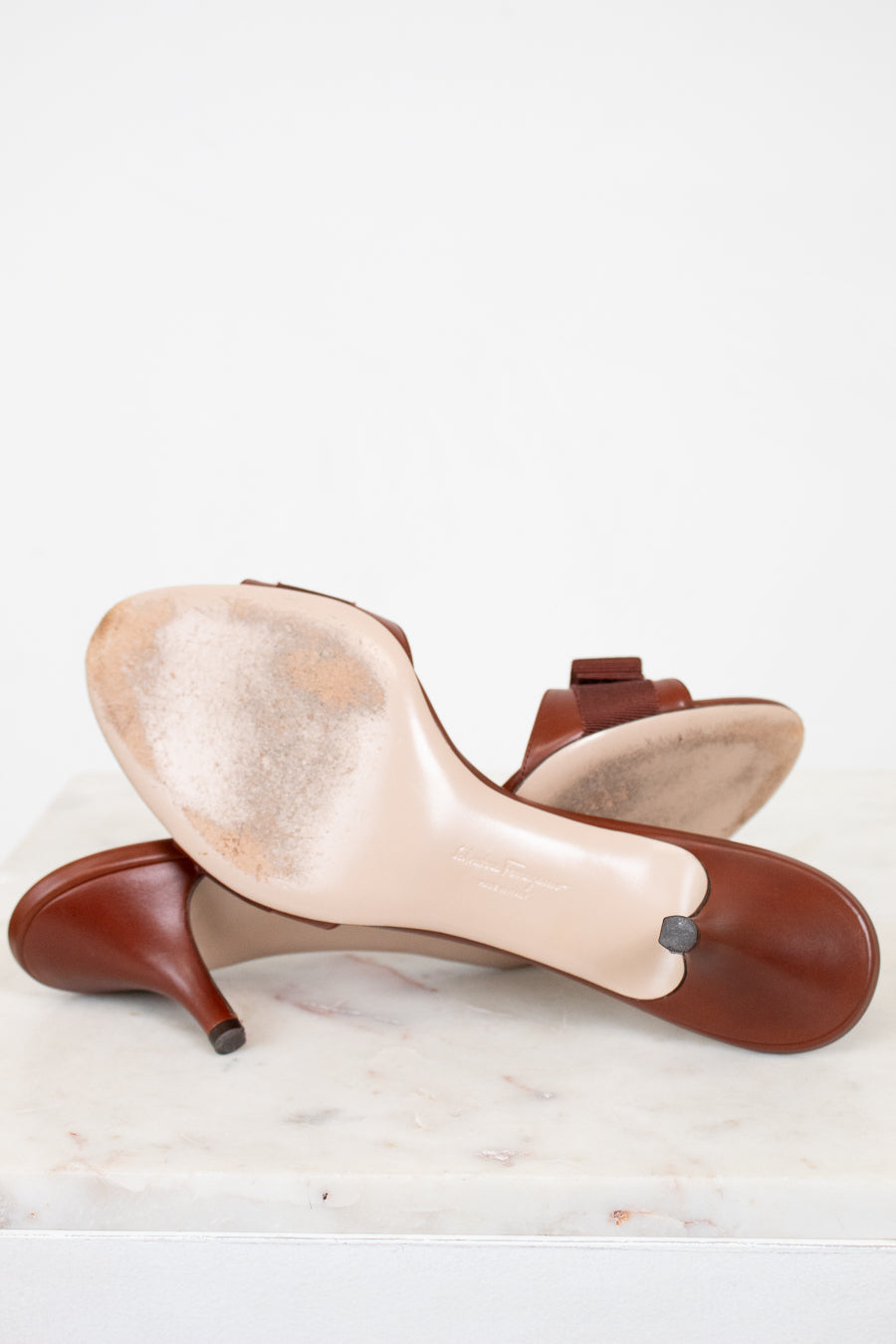 Pair of beige and brown high-heeled shoes on a white background