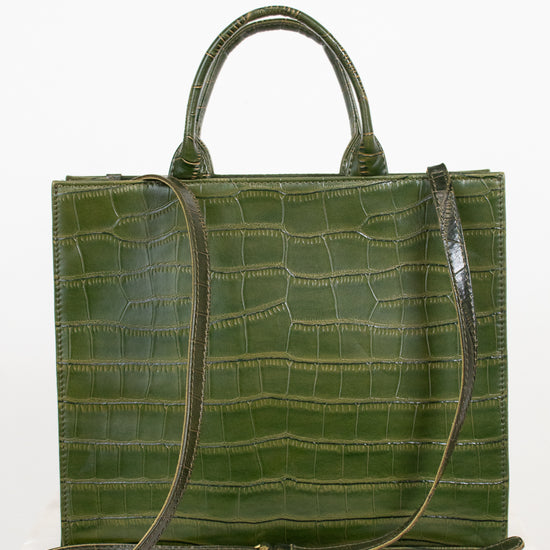 An olive green crocodile-embossed leather tote bag with dual top handles and a matching shoulder strap, displayed on a light marble surface against a white background.