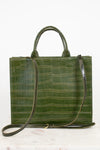 An olive green crocodile-embossed leather tote bag with dual top handles and a matching shoulder strap, displayed on a light marble surface against a white background.