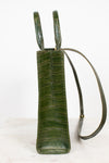 An olive green crocodile-embossed leather shoulder bag with a matching adjustable shoulder strap, shown against a plain white background.